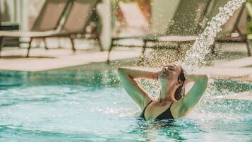 A person in a swimming pool with water splashing around them.