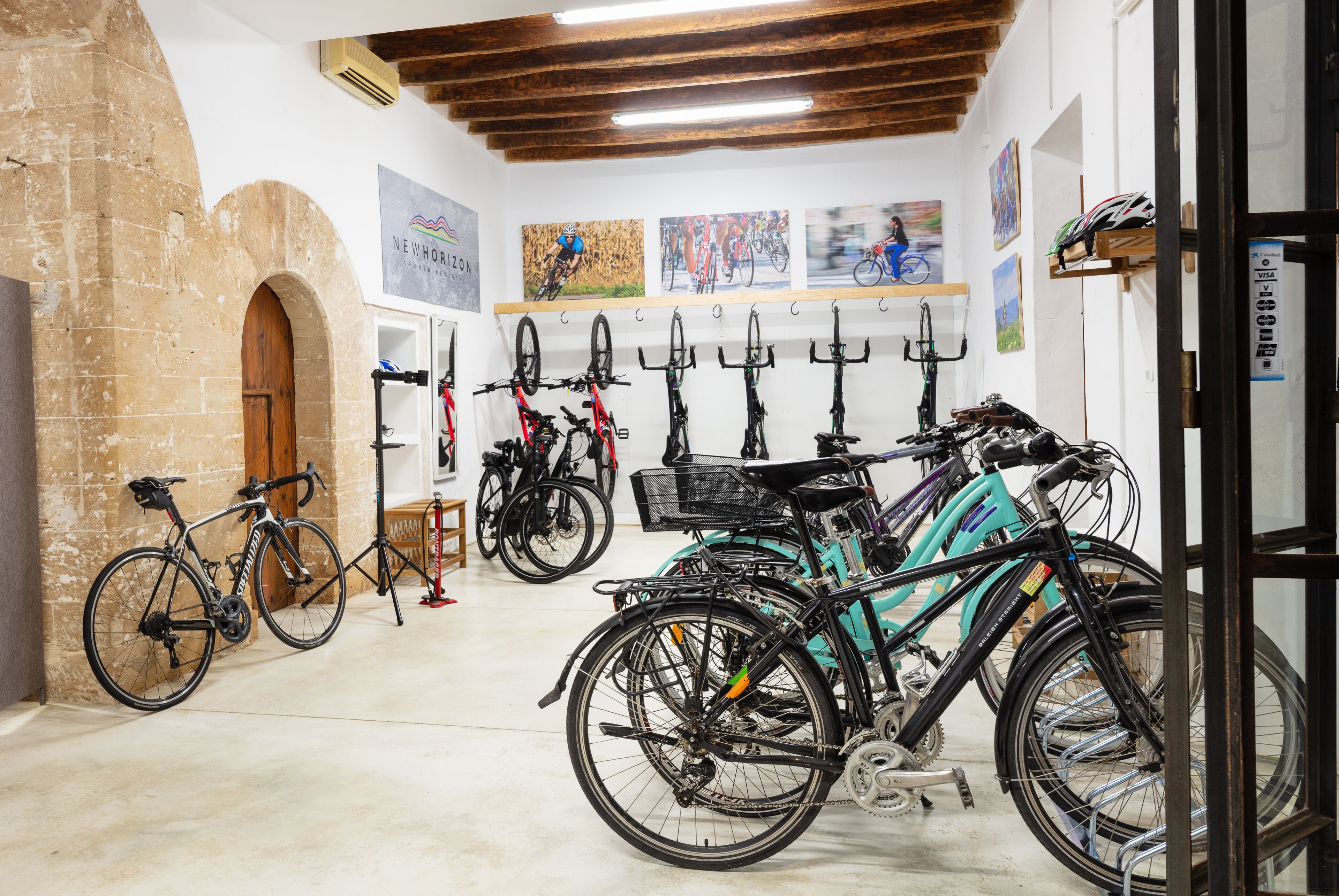 Uma loja de bicicletas com diversos modelos expostos e um muro de tijolos.