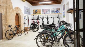 Uma loja de bicicletas com diversos modelos expostos e um muro de tijolos.