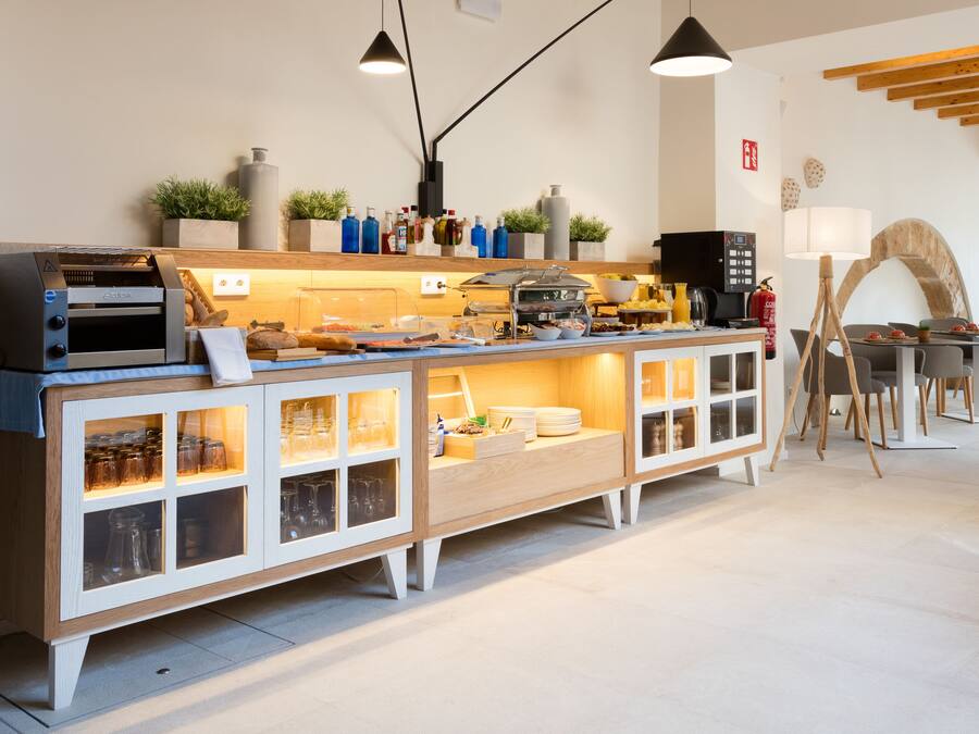 Een ontbijtbalk met een koffieapparaat, een broodrooster en diverse etenswaren.