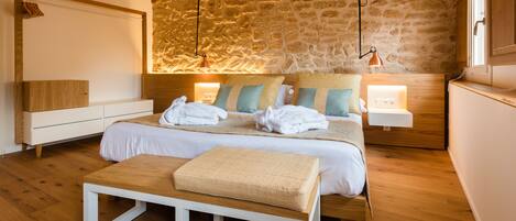 Ein modernes Schlafzimmer mit Steinwand, Holzmöbeln und zwei Nachttischlampen.