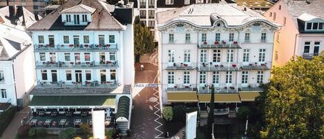 A multi-story hotel with balconies, a parking area, and a street view.
