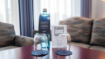 A table with a bottle, a QR code, and a glass on coaster.