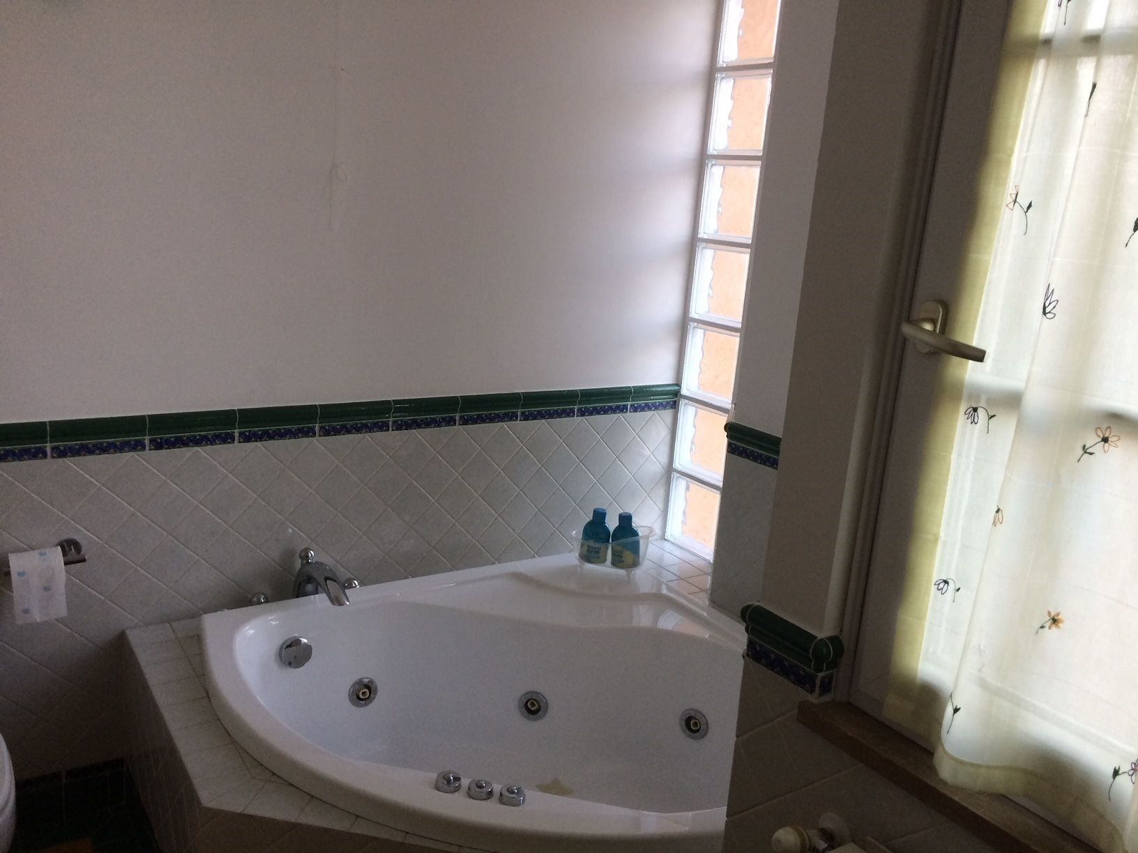A bathroom with a freestanding bathtub, a toilet, and a window with a view.