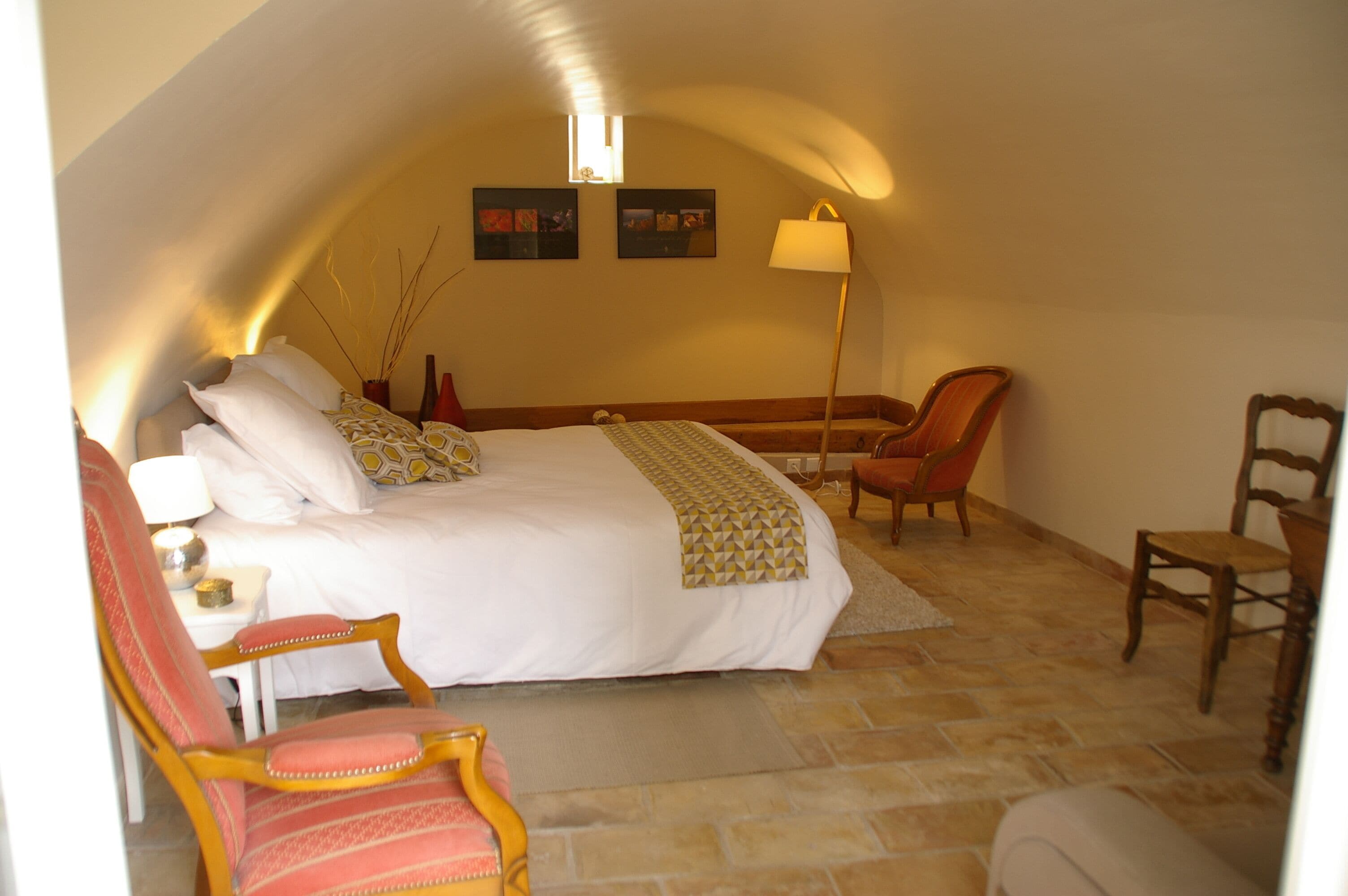 Une chambre avec un grand lit, un bureau et deux chaises.