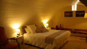 A cozy bedroom with a large bed, two bedside lamps, a chair, and a small table. - La Musardine en Vexin (Omerville)
