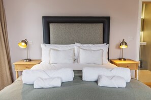 A neatly made bed with white linens and two bedside lamps. - Isle of Raasay Distillery (Isle of Raasay)