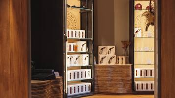 A modern hotel lobby with wooden flooring, a reception desk, and a display of framed photographs.