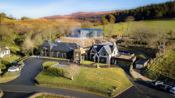 A large, modern house with multiple sections, including a large garage and a spacious outdoor area with a driveway. - Isle of Raasay Distillery (Isle of Raasay)