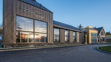 A modern building with large windows and a sign that reads "Isle of Raasay Distillery".