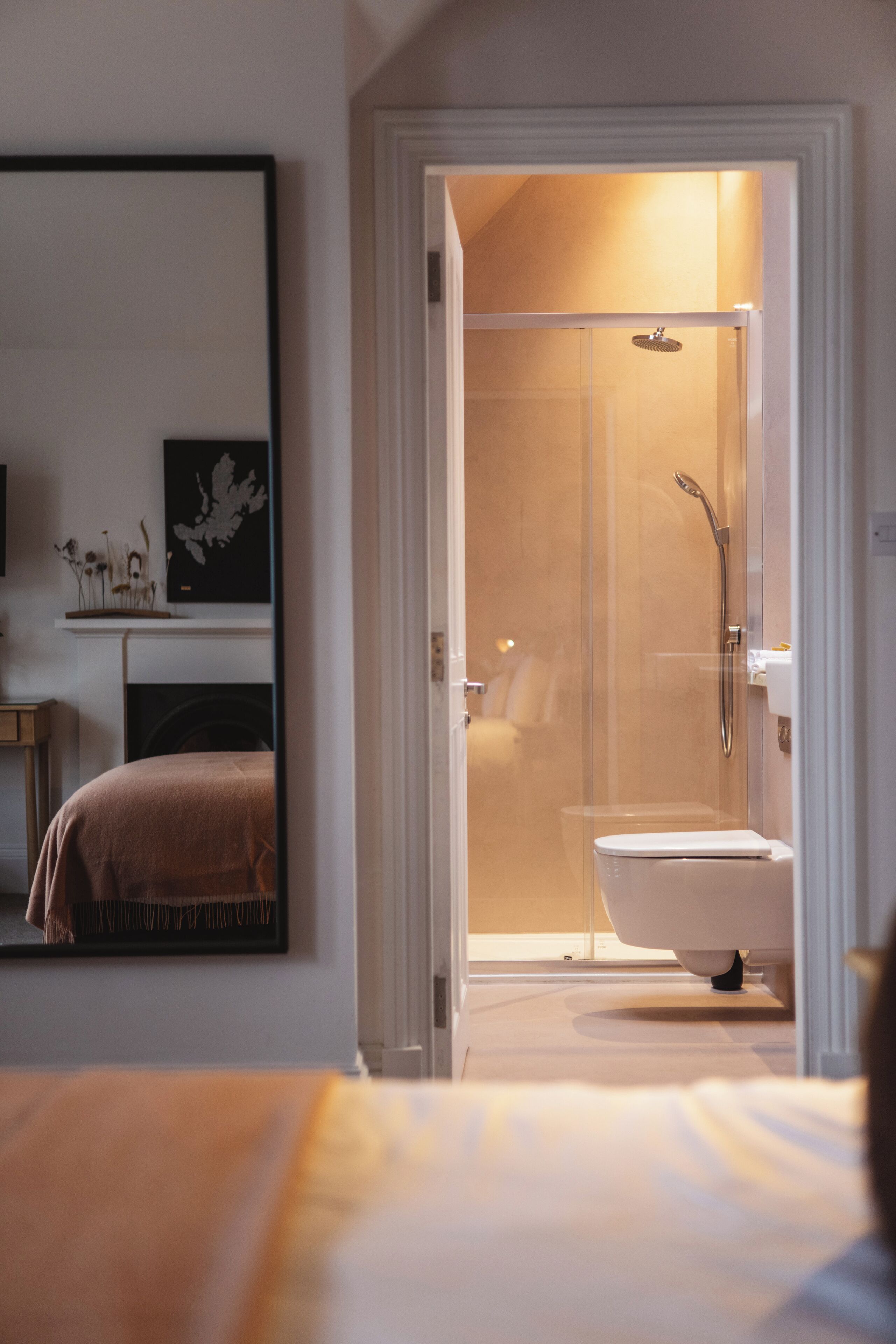 Une salle de bain moderne avec une douche à parois de verre, des toilettes blanches et un lavabo apparent.