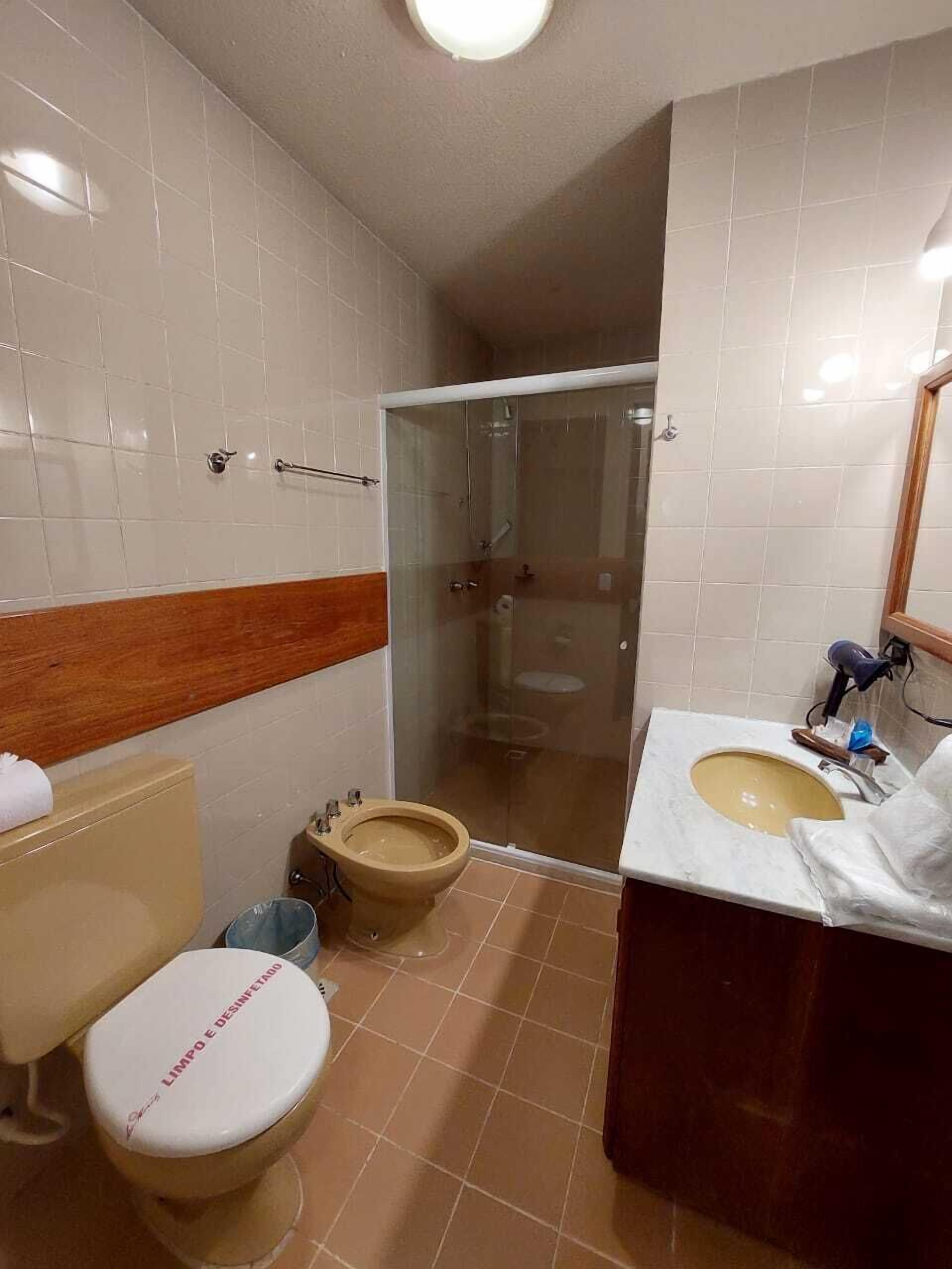 Ein Badezimmer mit Toilette, Bidet und einer Duschkabine.