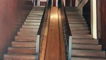 A wooden staircase with metal railings leading to a door at the top.