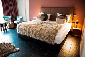 A large bed with a fluffy blanket, two chairs, a small table, and a lamp. - Jagdschloss Windenhütte (Thale)