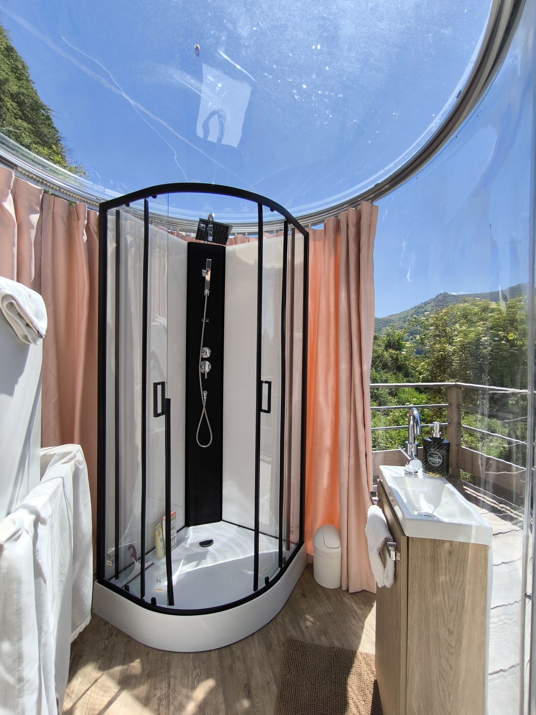 Un baño moderno con cabina de vidrio, ducha y lavamanos.
