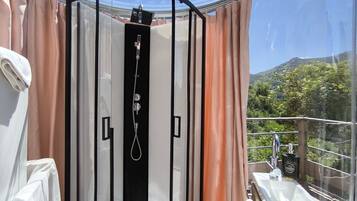 Un baño moderno con cabina de vidrio, ducha y lavamanos.