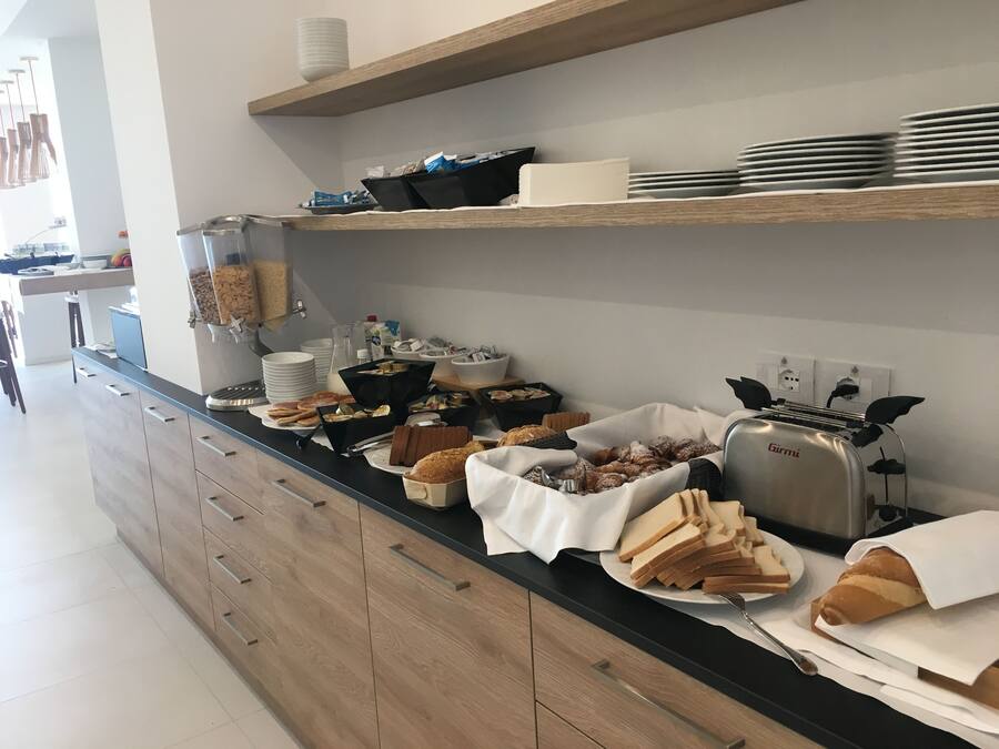 Un buffet proposant une variété d’aliments, notamment du pain, des viennoiseries et un grille-pain.
