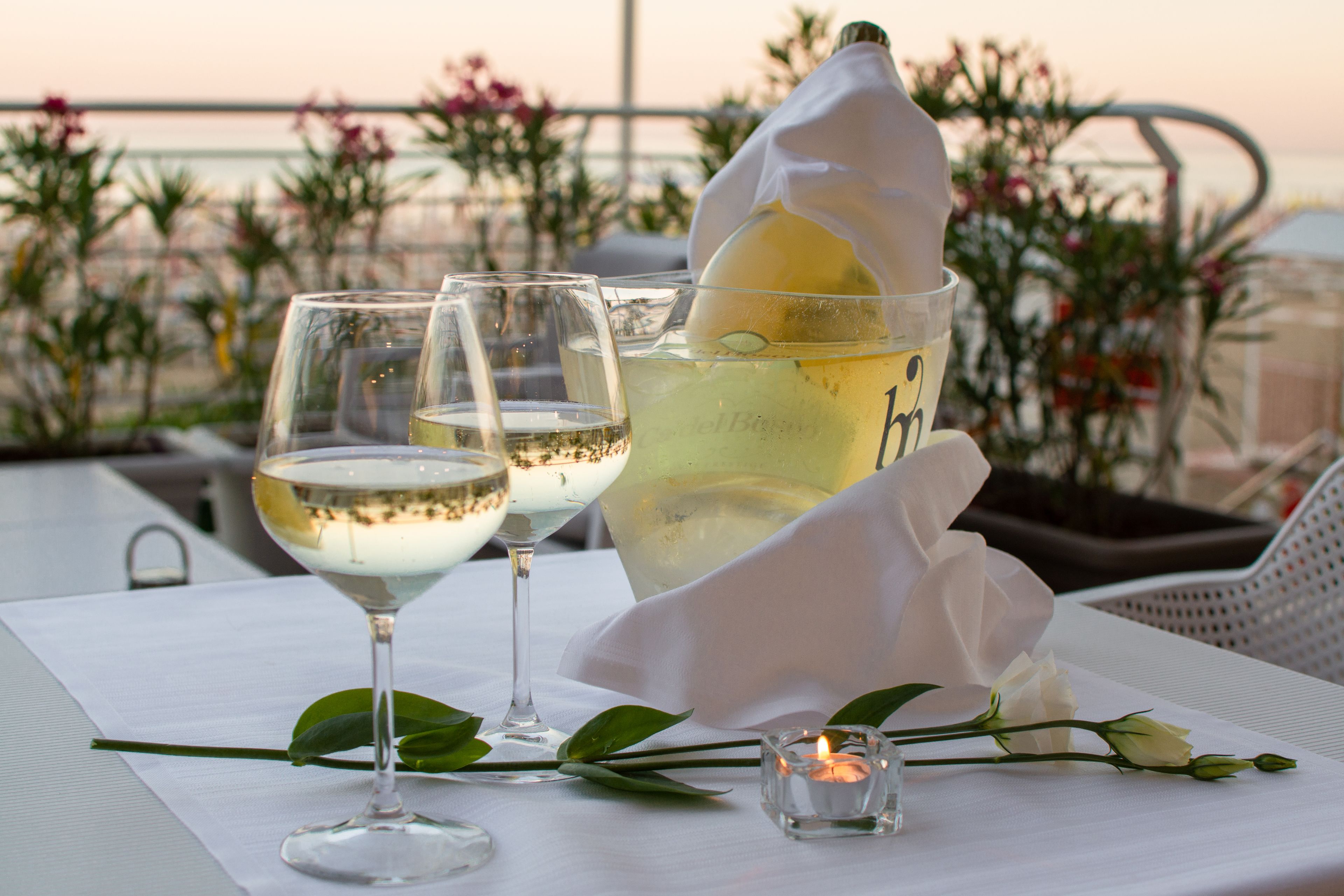 A table with two wine glasses, a pitcher, and a candle.
