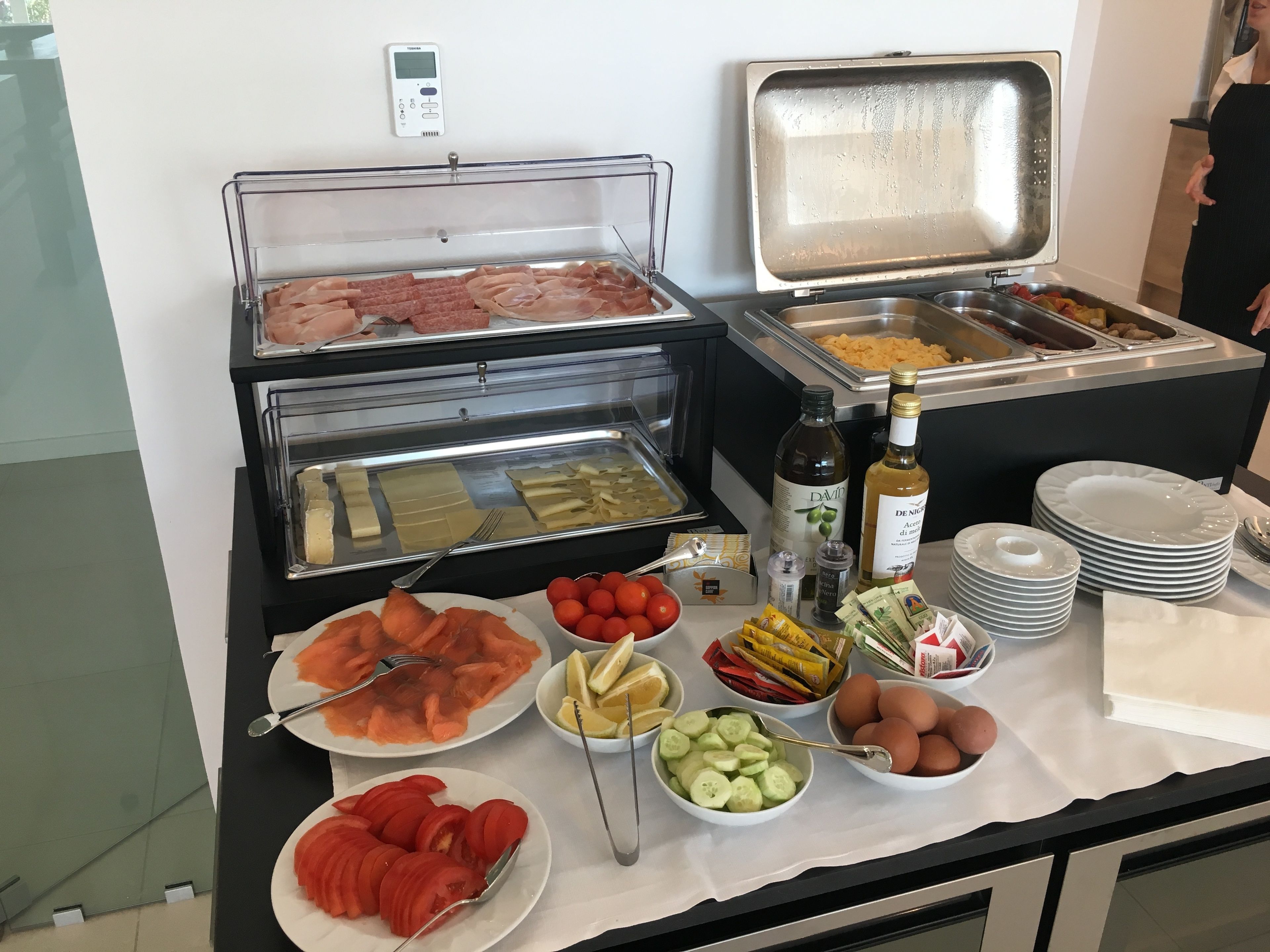 Un buffet proposant une variété de plats, notamment des viandes, des fromages et des fruits.