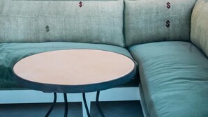 A green sofa with a round table in front of it.