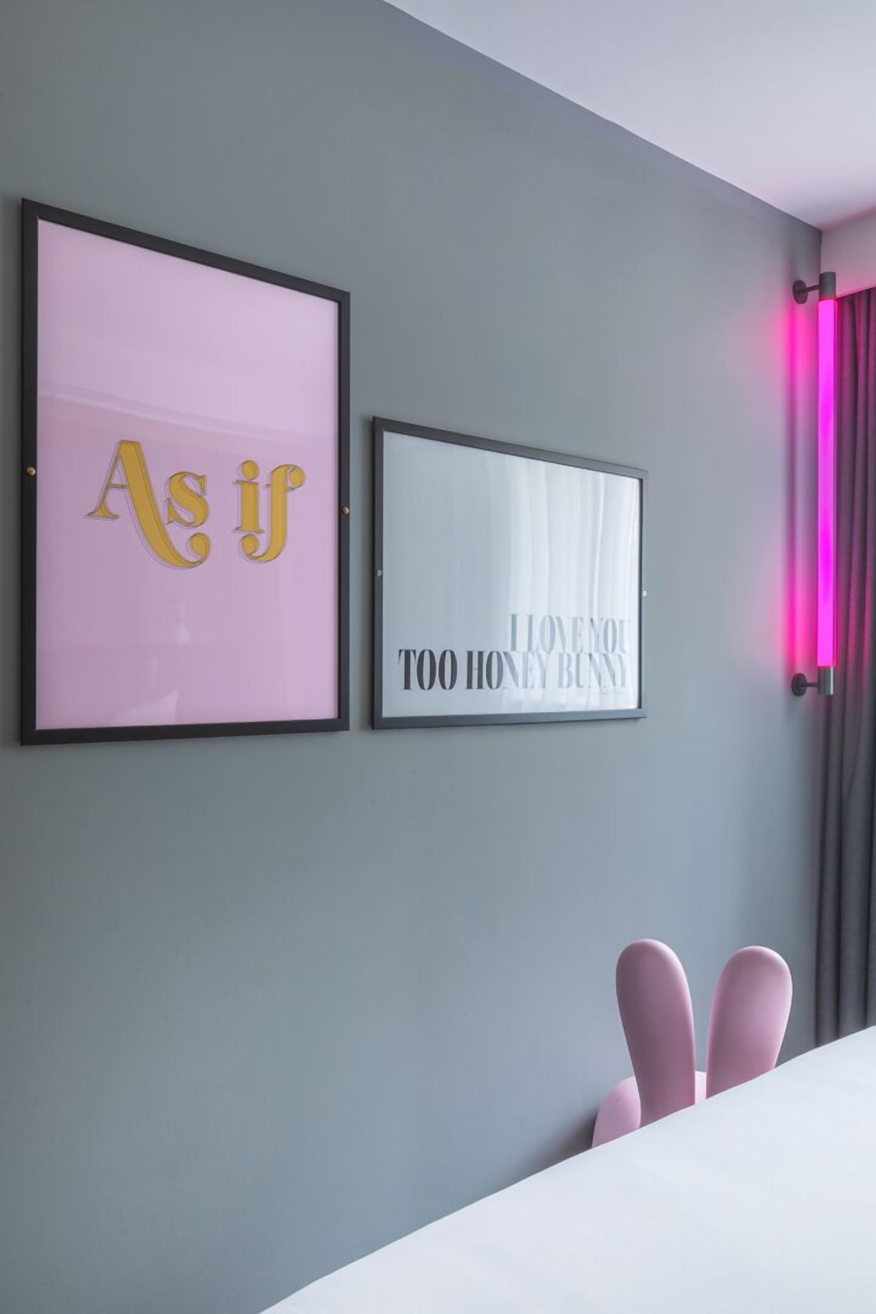 Two framed signs on a wall, one with the text "As if" and another with "I love you to honey bunny."