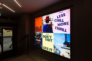 A digital display with various text messages and images, including "ASSEMBLY," "GET LOST," "DON'T VISIT LIVE IT," and "LESS CHILL MORE THRILL." - Assembly Leicester Square (London)