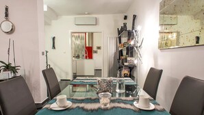 Un comedor moderno con una mesa de vidrio, sillas de cuero y un corredor decorativo.