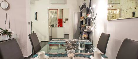 Un comedor moderno con una mesa de vidrio, sillas de cuero y un corredor decorativo.