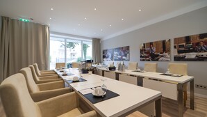 A modern conference room with a long table, multiple chairs, and artwork on the walls. - City Hotel Bosse (Bad Oeynhausen)