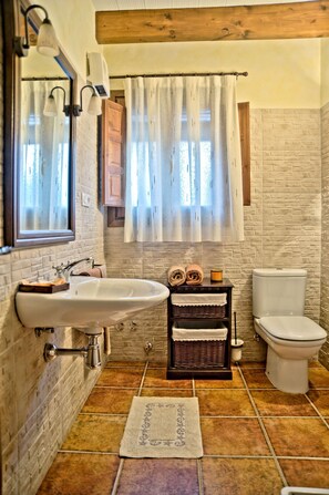 Ein Badezimmer mit einem weißen Waschbecken, einer Toilette und einer Duschkabine.