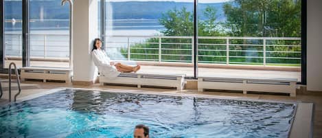 Una piscina techada, una piscina al aire libre de temporada, sombrillas