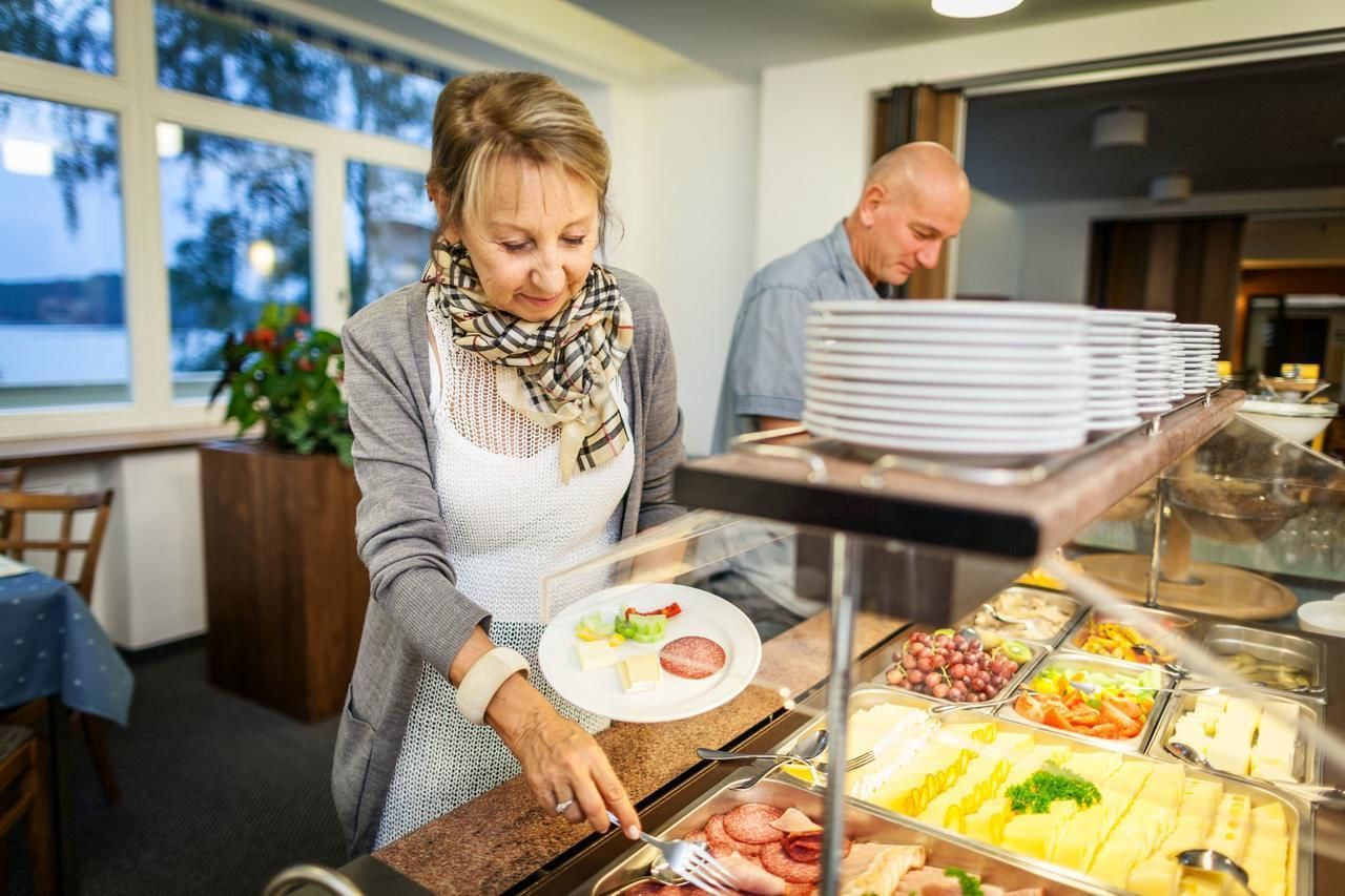 A buffet area with various food items and a person serving.