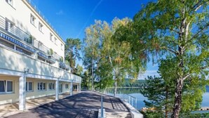 Ein Hotel am Ufer mit einer überdachten Galerie und Blick auf den See.