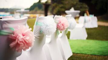 Una fila de mesas blancas con centros de mesa decorados con motivos florales en rosa y blanco.