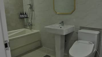 A bathroom with a bathtub, sink, and toilet.