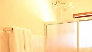 Een badkamer met een douche, toilet en wastafel.