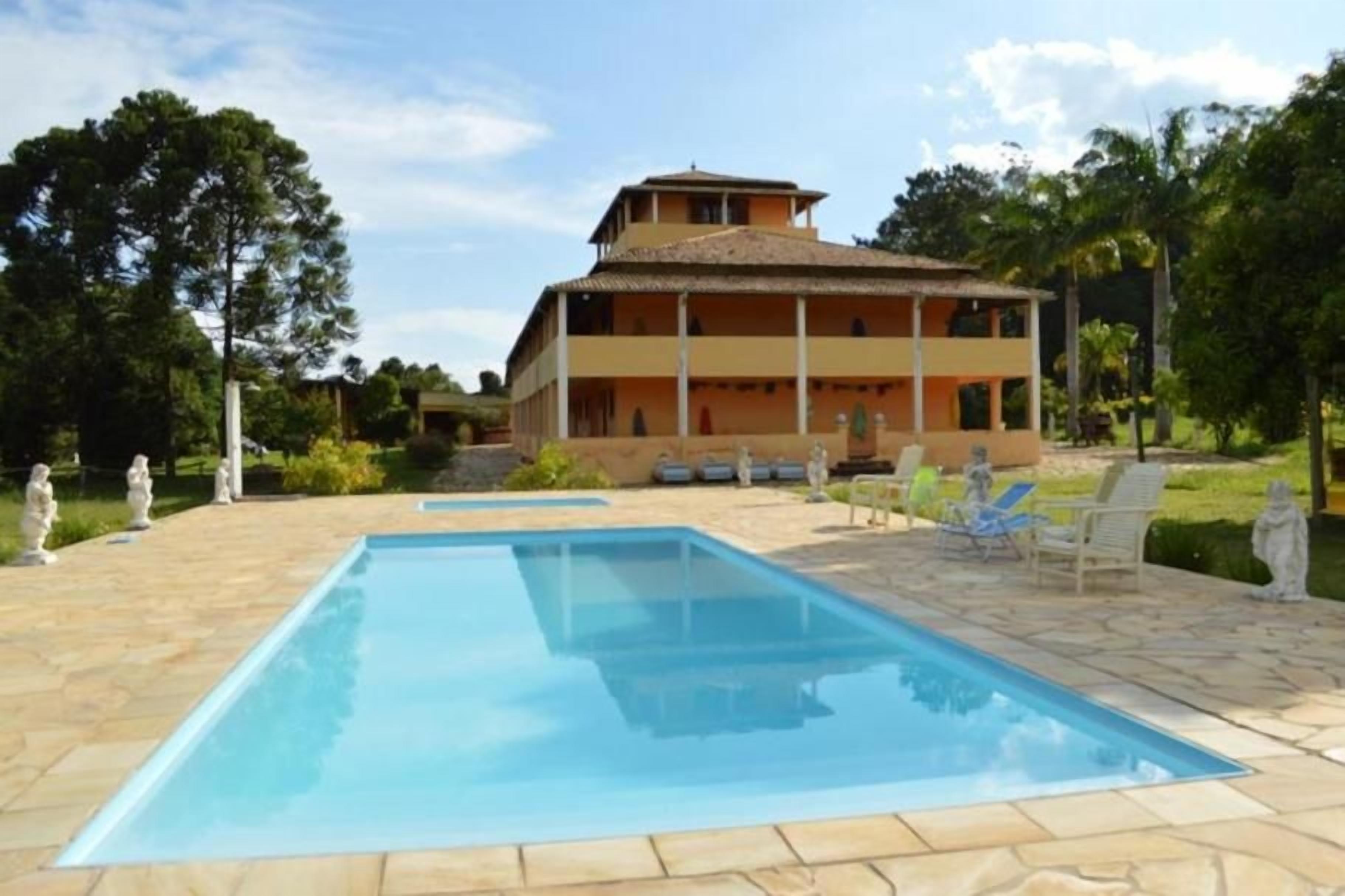 Um edifício de dois andares com piscina na frente.