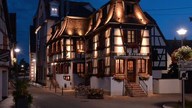 Un hotel europeo tradicional con un cartel que indica que también es restaurante.