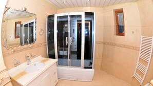 Un bany amb dutxa trencada per vidre, un lavabo amb mirall i un vàter.