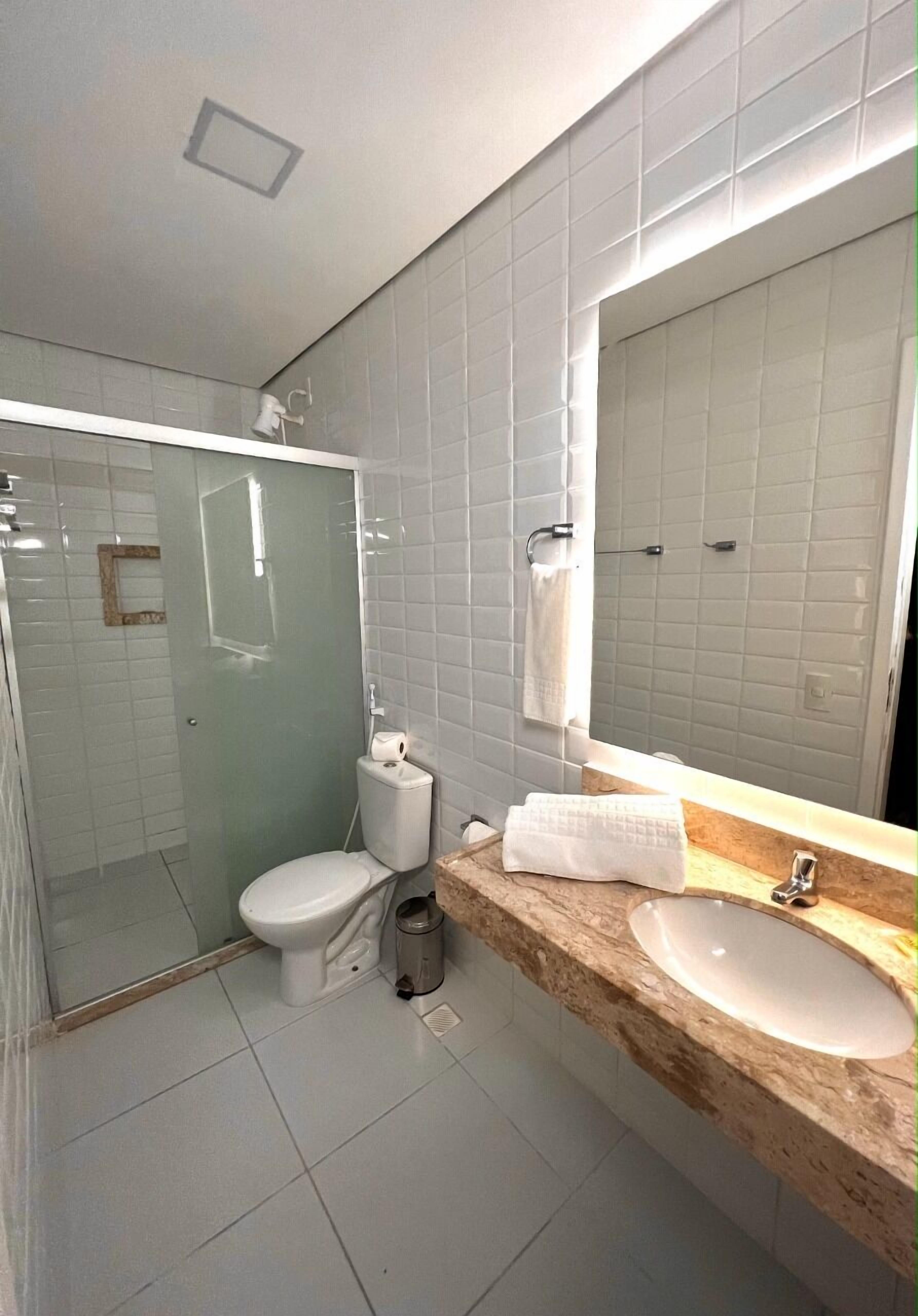 Un baño con inodoro, lavamanos y ducha.