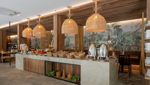 A buffet area with a stone floor, wooden paneling, and tropical-themed wall art. - Pauli Boutique Hotel  (Fortaleza)
