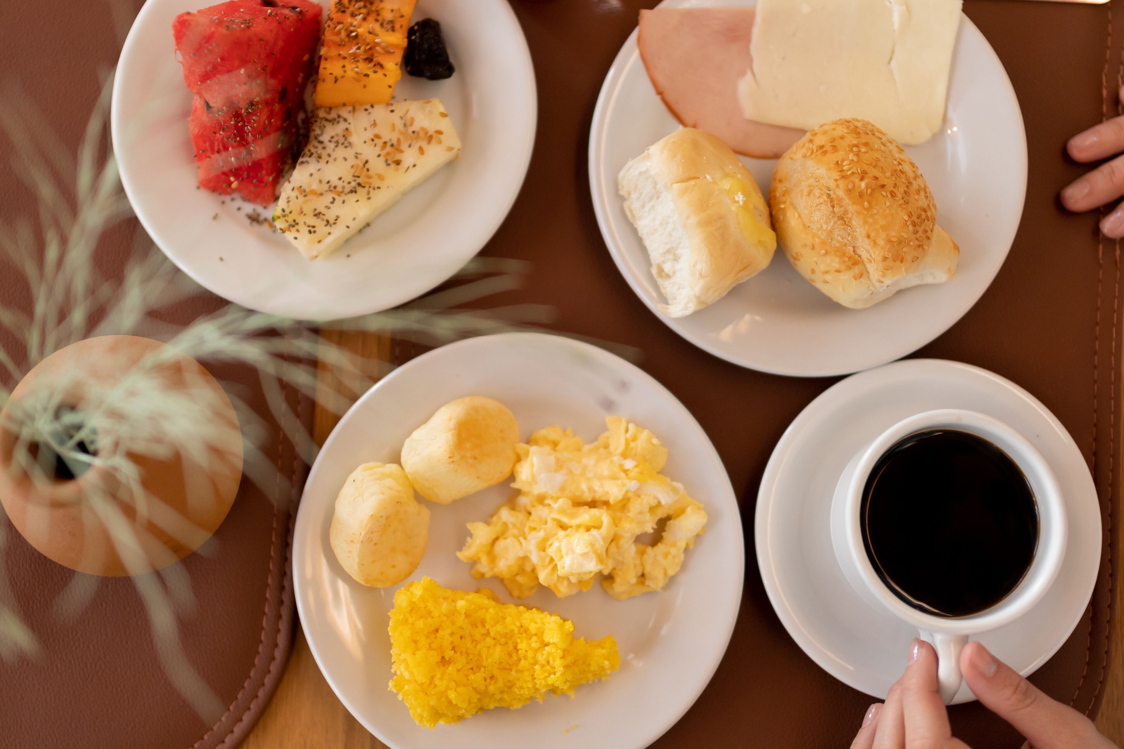 A breakfast setting with plates of food, including scrambled eggs, toast, and a cup of coffee.