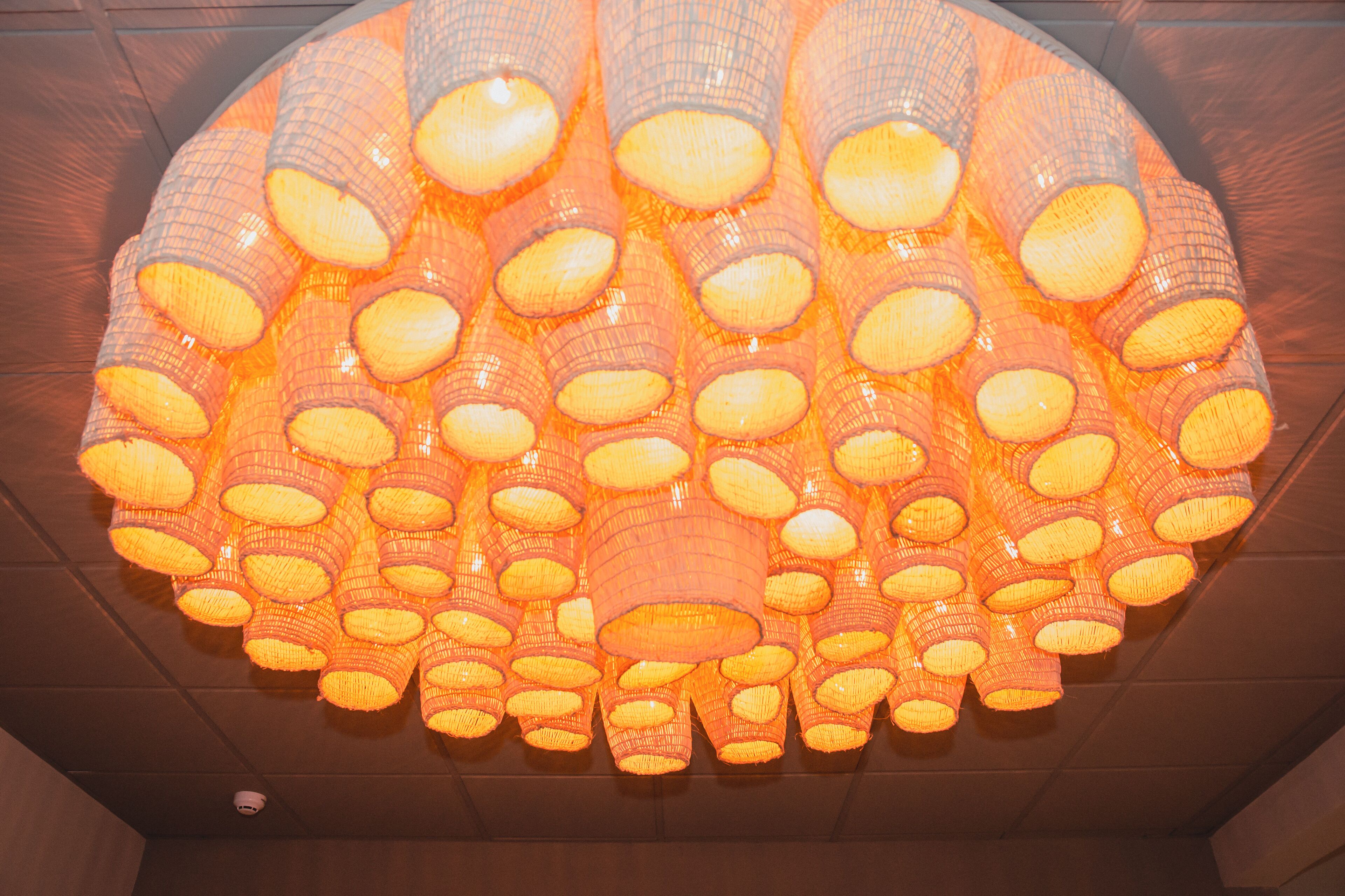 A large, circular chandelier with multiple orange and white light fixtures.