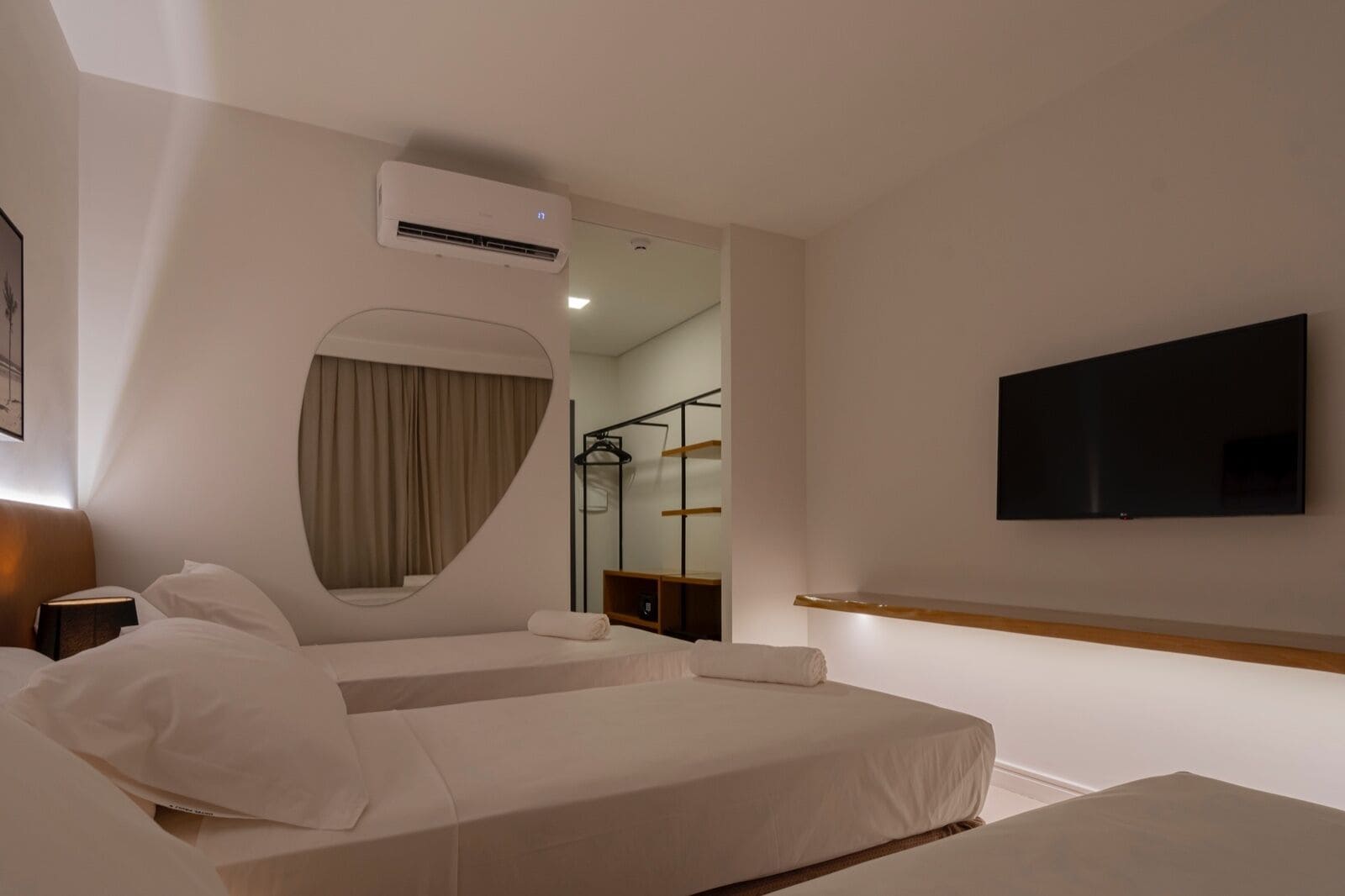 Une chambre d’hôtel équipée d’un lit, d’une télévision, d’un climatiseur et d’un miroir.