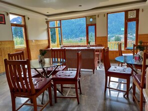 Enjoy meals in this cozy dining area with a round table and comfortable chairs, surrounded by stunning mountain views.