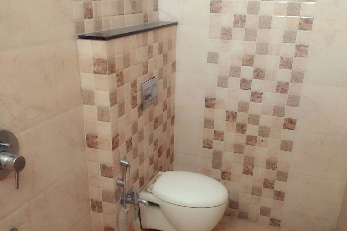 A small bathroom with a toilet, a sink, and a trash bin.