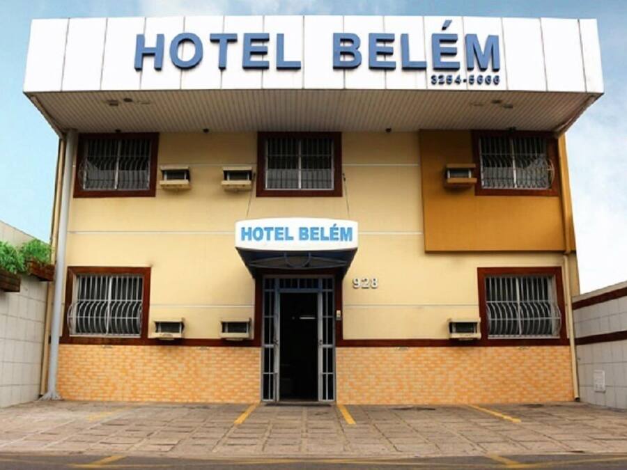 A building with a sign reading "HOTEL BELÉM" and a phone number.