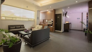 A modern living room with a sofa, coffee table, and potted plants. - Tierra Viva Hotel (Comitan de Dominguez)