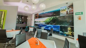 A restaurant with multiple dining tables, chairs, and hanging spherical light fixtures. - Tierra Viva Hotel (Comitan de Dominguez)