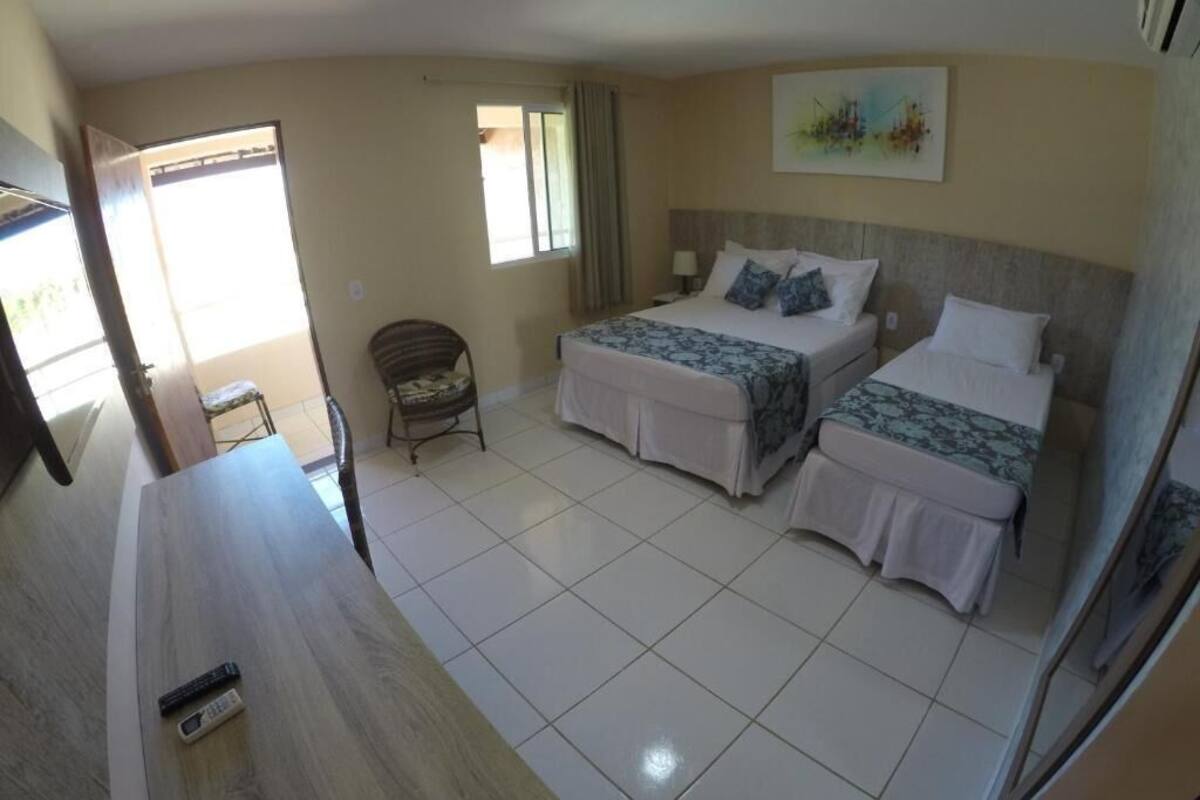 A hotel room with two beds, a desk, and a chair.